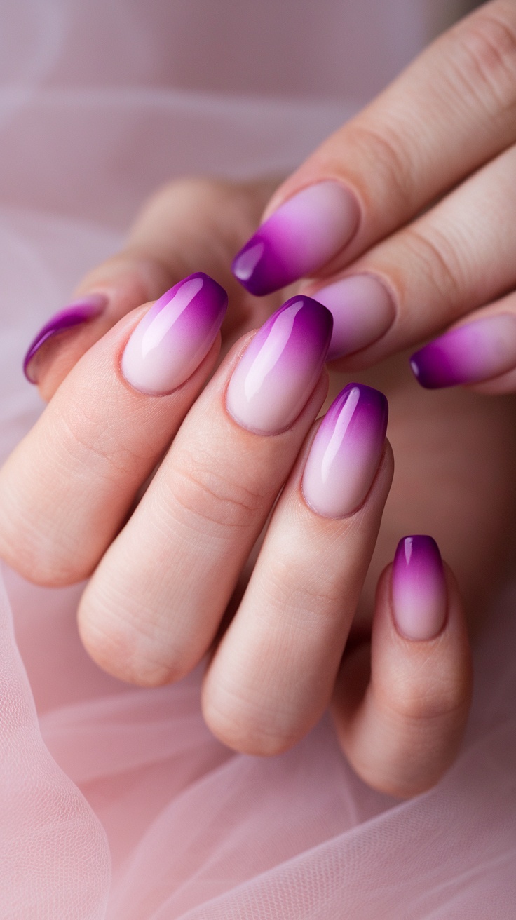 Close-up of hands with gradient ombre nails blending purple and pink colors.