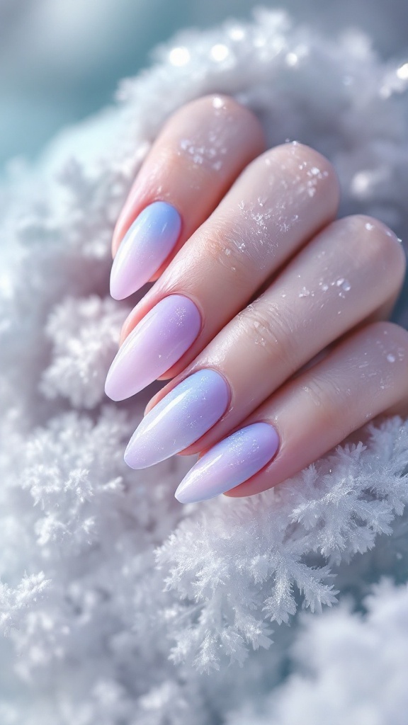 A hand with icy pastel ombre nails, featuring light blue and white colors